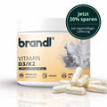 Brandl vitamin d3/k2 kapseln in weißem zylinder mit orangefarbenem etikett und transparenten kapseln am boden