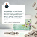 Ein zylindrischer behälter mit bio mönchspfeffer extrakt in grauen kapseln und grün-weißem etikett mit lila blüten
