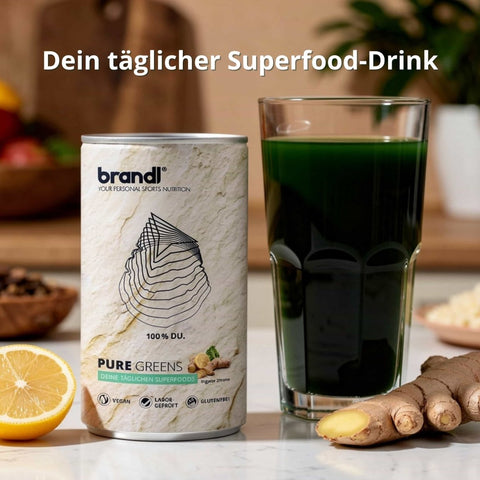 Eine schlanke silberne dose brandl pure greens superfood drink mit minimalistischem weißen etikett und grünen akzenten