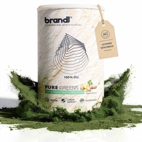Ein weißer zylinderbehälter der marke brandl mit pure greens superfoods pulver und grünem pulver am boden