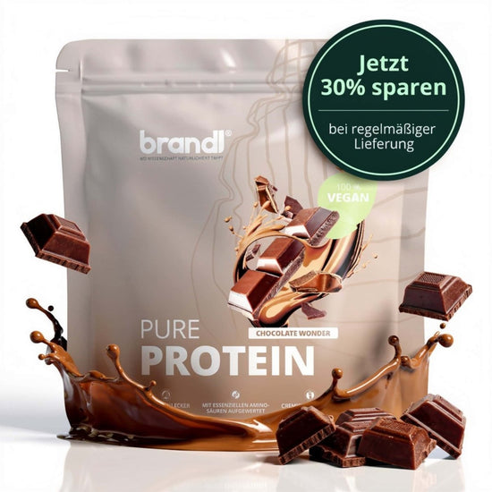 Ein schlanker silberner beutel von brandl pure protein 2.0 vegan schokolade wonder mit schokoladensplash und stückchen