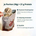 Eine hand hält eine klare plastikschaufel mit beigem proteinpulver über einem offenen beutel von brandl pure protein muskelaufbau bundle xl