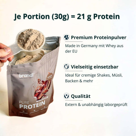 Eine hand hält eine klare plastikschaufel mit beigem proteinpulver über einem offenen beutel von brandl pure protein muskelaufbau bundle xl