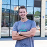 Graues heathered T-Shirt mit einem türkisfarbenen Logo und Text über der Brust